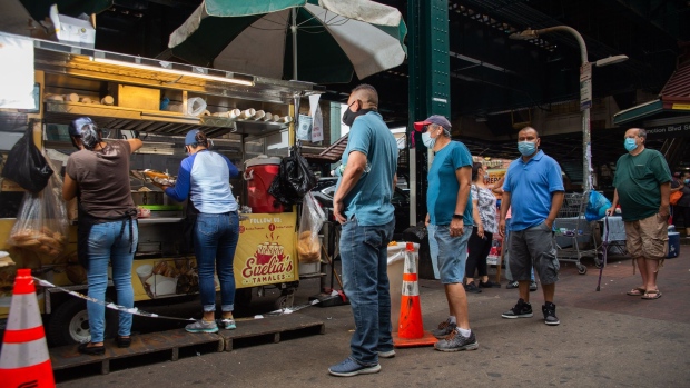 Customers stand in line outside Evelia's Tamales food cart in the Corona neighborhood in the Queens borough of New York, U.S., on Saturday, June 27, 2020. Owner Evelia Coyotzi -- who sells tamales, the popular Mexican dish wrapped in corn husks -- didn't apply for the federal Payment Protection Program because she had been rejected by her bank for a loan in the past.