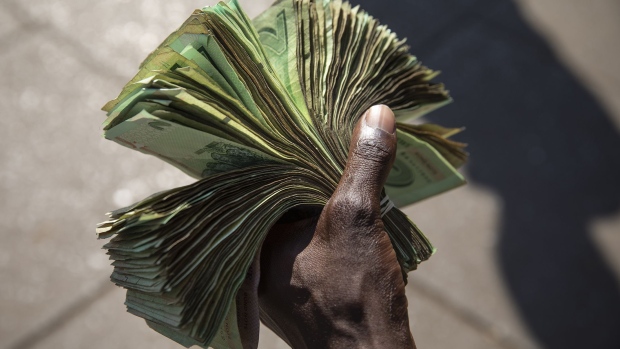 HARARE, ZIMBABWE - AUGUST 05: A man holds Zimbabwean Dollar Bond Notes on August 05, 2018 in Harare, Zimbabwe. Zimbabwe Electoral Commission (ZEC) officials have announced the re-election of President Emmerson Mnangagwa of the ruling Zimbabwe African National Union - Patriotic Front (ZANU-PF). The election was the first since Robert Mugabe was ousted in a military coup last year, and featured a close race between Mnangagwa and opposition candidate Nelson Chamisa of the Movement for Democratic Change (MDC Alliance). Deadly clashes broke out earlier in the week following the release of parliamentary election results, amid allegations of fraud by Chamisa and MDC supporters. (Photo by Dan Kitwood/Getty Images) Photographer: Dan Kitwood/Getty Images Europe