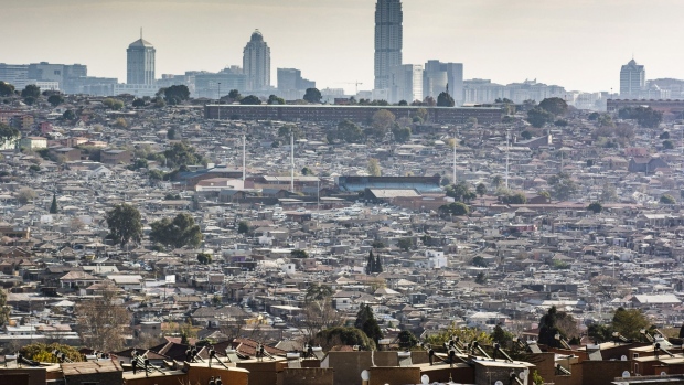 Residential housing stands in the Alexandra township as the skyscraper office buildings in the Sandton area stand on the skyline beyond in Johannesburg, South Africa, on Thursday, June 11, 2020. The near-decade of mismanagement and corruption under former President Jacob Zuma combined with the coronavirus outbreak and loss of South Africa’s investment-grade rating have left the economy in its worst state in the democratic era. Photographer: Waldo Swiegers/Bloomberg