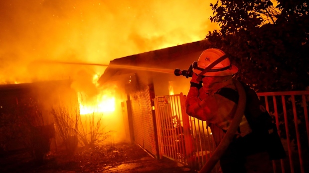 PARADISE, CA - NOVEMBER 08: Firefighters try to contain a fire so it doesn't spread to a neighboring building as the Camp Fire moves through the area on November 8, 2018 in Paradise, California. Fueled by high winds and low humidity, the rapidly spreading wildfire has ripped through the town of Paradise, charring 18,000 acres and destroying dozens of homes in a matter of hours. The fire is currently at zero containment. (Photo by Justin Sullivan/Getty Images)