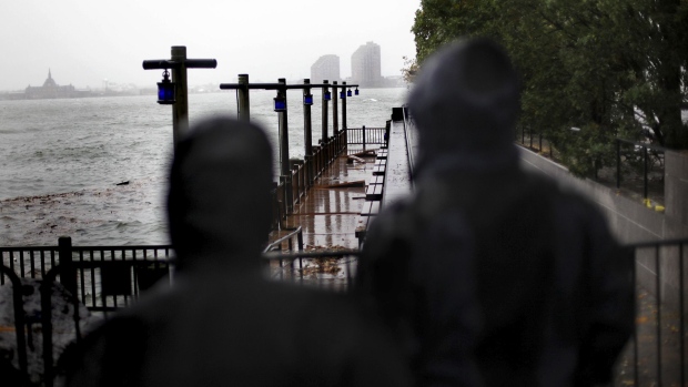 People look at a damaged boardwalk in the Battery Park neighborhood of Manhattan. Photographer: Allison Joyce/Getty Images North America