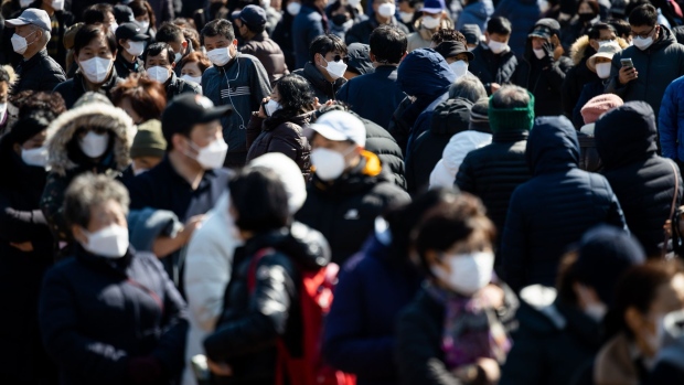 People wait in line to buy protective masks at a Hanaro Mart supermarket, operated by the National Agricultural Cooperative Federation (Nonghyup), in the Seocho district of Seoul, South Korea, on Thursday, March 5, 2020. South Korea's government said its seeking a 11.7 trillion won ($9.8 billion) extra budget to help businesses hit by the worlds second-largest coronavirus outbreak, joining policy makers around the globe intensifying responses to the epidemic. Photographer: SeongJoon Cho/Bloomberg