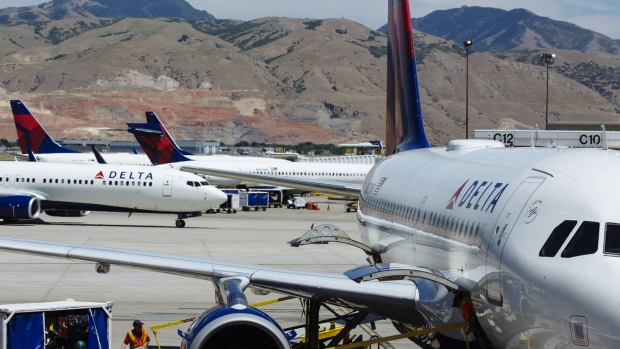 A ground crew member loads baggage on a Delta Air Lines Inc. plane at Salt Lake City International airport (SLC) in Salt Lake City, Utah. Photographer: Angus Mordant/Bloomberg