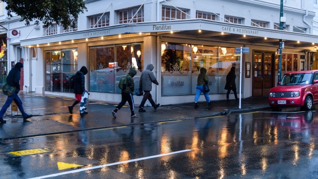 Pedestrians walk along a sidewalk past a restaurant in Wellington, New Zealand, on Thursday, June 18, 2020. New Zealand entered recession for the first time in almost a decade as the coronavirus pandemic led to the nations biggest quarterly contraction in 29 years.