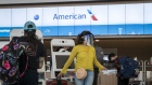Travelers wearing protective masks use kiosks to check-in at the American Airlines Group Inc. counter at San Francisco International Airport (SFO) in San Francisco, California, U.S., on Wednesday, July 1, 2020. American Airlines said it would sell flights to capacity starting July 1, abandoning caps on passenger loads that were designed to promote social distancing amid the coronavirus pandemic.