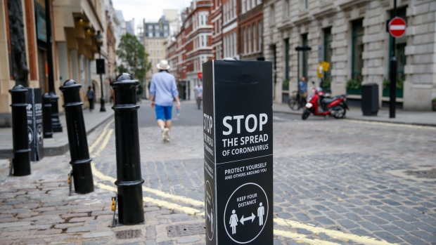 A coronavirus sign stands on a bollard in the Covent Garden district of London on June 15. Photographer: Hollie Adams/Bloomberg