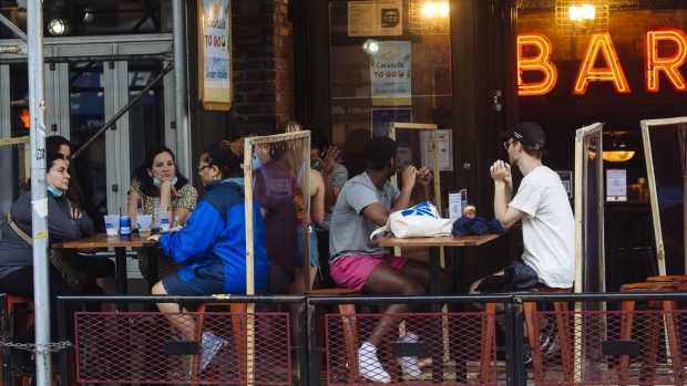 People sit outside a bar in the East Village neighborhood of New York on July 6, 2020.