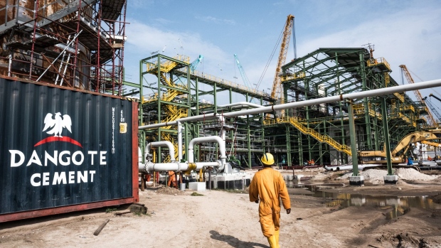 A Dangote Cement Plc logo stands on a barrier at the under-construction Dangote Industries Ltd. oil refinery and fertilizer plant site in the Ibeju Lekki district, outside of Lagos, Nigeria, on Thursday, July 5, 2018. The $10 billion refinery, set to be one of the world’s largest and process 650,000 barrels of crude a day, should be near full capacity by mid-2020, Devakumar Edwin, group executive director at Dangote Industries said in an interview.