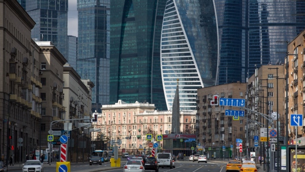 Automobiles travel along a road past skyscrapers of Moscow International Business Center (MIBC), also known as Moscow City, stand beyond in Moscow, Russia, on Tuesday, April 28, 2020. Russia has reported 93,558 confirmed Covid-19 cases. Photographer: Andrey Rudakov/Bloomberg