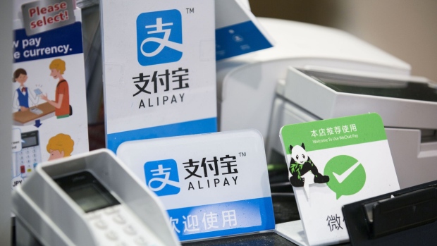 Signs for Ant Financial Services Group's Alipay, an affiliate of Alibaba Group Holding Ltd., center top and center bottom, and Tencent Holdings Ltd.'s WeChat Pay, right, are displayed at a Takeya Co. Ueno Select shop in Tokyo, Japan.