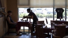 A server wearing a protective mask delivers a customer's order at a restaurant on its first day of reopening and the first day of indoor dining in Ottawa, Ontario, Canada, on Friday, July 17, 2020. Twenty-four districts, including Ottawa and Waterloo, are moving into the final stage of the three-part reopening plan as Covid-19 infections continue to drop.
