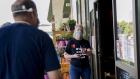 A worker wearing a protective mask manages store capacity at a Loblaws store in Ottawa, Ontario, Canada, on Friday, July 10, 2020. Major grocery chains said they would boost front-line workers' wages in March due to the pandemic but ended the pay bump late last month, CTV News reported.