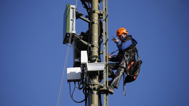 An engineer speaks on a radio device during the installation of Ericsson AB 5G apparatus to a Swisscom AG telecommunication network mast in Hindelbank, Switzerland.