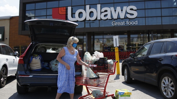A customer loads groceries into her vehicle outside a Loblaws store in Ottawa on July 10.