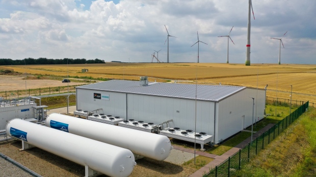 Wind turbines stand in view of the hydrogen electrolysis plant stands at Energiepark Mainz, operated by Linde AG, in Mainz, Germany, on Friday, July 17, 2020. Europe is pinning its green hopes on hydrogen in a plan that sees hundreds of billions of euros in investment flowing into the clean technology and fueling a climate-friendly economic recovery.