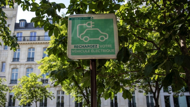 An electric vehicle charging station street sign sits on display in Paris, France, on Wednesday, May 27, 2020. President Emmanuel Macron’s plan includes incentives for the purchase of electric cars, cash-for-clunkers to encourage consumers to trade in older, more polluting cars and subsidies for struggling car-parts makers. Photographer: Adrienne Surprenant/Bloomberg