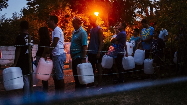 Residents queue to fill plastic water bottles and containers as night falls at the Newlands natural water spring in Cape Town in 2018.