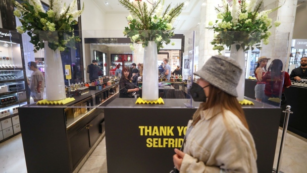 A shopper wearing a protective face mask passes a perfume counter surrounded by a protective screen in Selfridges & Co Ltd. department store in London, U.K., on Monday, June 15, 2020. British Prime Minister Boris Johnson encouraged consumers to go out and "shop with confidence" when stores reopen in England on Monday, as he suggested social distancing rules will be eased. Photographer: Chris Ratcliffe/Bloomberg