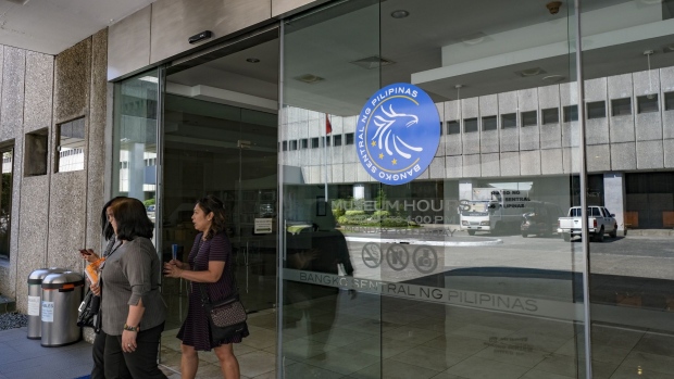 People exit the Bangko Sentral ng Pilipinas headquarters in Manila, the Philippines, on Thursday, Feb. 7, 2019. The Philippines central bank left its benchmark interest rate unchanged for a second straight policy meeting, while cutting inflation forecasts for this year and next. Photographer: Veejay Villafranca/Bloomberg