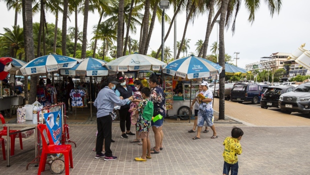 Visitors wearing protective masks receive hand sanitizer and have their temperature checked at an entrance screening point at Bangsaen Beach in Chonburi, Thailand, on Sunday, June 14, 2020. Thailand said a number of countries, including China and Japan, are interested in discussions about travel bubbles, as the nation considers protocols for the eventual return of foreign tourists. Local tourism has already restarted. Photographer: Andre Malerba/Bloomberg
