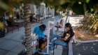 A worker gives a pedicure to a customer outside of a nail salon in Palo Alto, California, on July 28. Photographer: David Paul Morris/Bloomberg