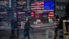 Monitors displaying stock market information are seen through the window of the Nasdaq MarketSite in the Times Square neighborhood of New York, U.S., on Thursday, March 19, 2020. New York state Governor Andrew Cuomo on Thursday ordered businesses to keep 75% of their workforce home as the number of coronavirus cases rises rapidly.