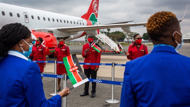 Cabin crew members from Kenya Airways Ltd. wait to welcome passengers onto an aircraft during a reopening ceremony at Jomo Kenyatta International Airport in Nairobi, Kenya, on Wednesday, July 15, 2020. Kenya Airways Plc started a three-month round of job cuts as lawmakers debate a bill to nationalize the carrier and its losses mount due to the impact of the coronavirus pandemic.