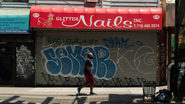 A pedestrian wearing a protective mask walks past a closed nail salon in the Williamsburg neighborhood in the Brooklyn borough of New York, U.S., on Wednesday, June 17, 2020. New York City moved toward more reopenings, allowing outdoor dining and salon services next week, while several U.S. states showed less encouraging trends.