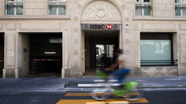 A cyclist passes a HSBC Holdings Plc bank branch in Paris, France, on Wednesday, July 29, 2020. HSBC is in the process of selling its French retail banking arm, which comprises 250 branches and several thousand employees. Photographer: Nathan Laine/Bloomberg