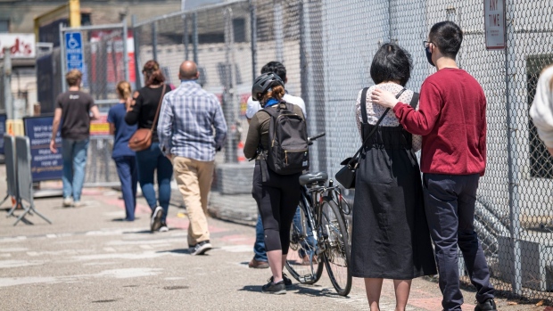 People wearing protective masks wait in line to get a Covid-19 swab test at a testing site in San Francisco, California, U.S., on Thursday, July 30, 2020. California recorded 194 new virus deaths, second only to the 197 reported Wednesday and above the 14-day average of 112.