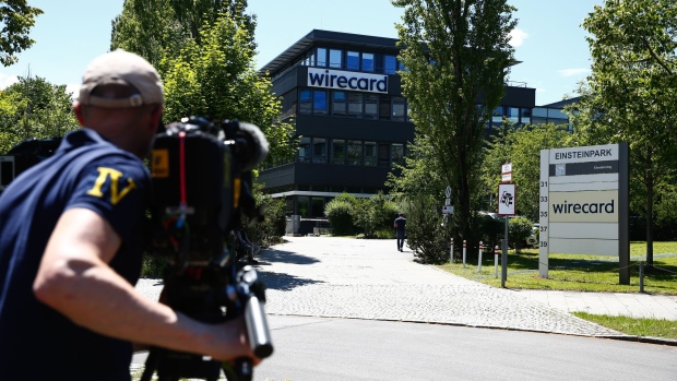 A television news camera operator films outside the Wirecard AG headquarters during a police and prosecutors raid in Munich, Germany, on Wednesday, July 1, 2020. Wirecard offices in Germany and two locations in Austria were raided by Munich prosecutors looking into the 1.9 billion euros ($2.1 billion) that went missing from the fintech company’s accounts.