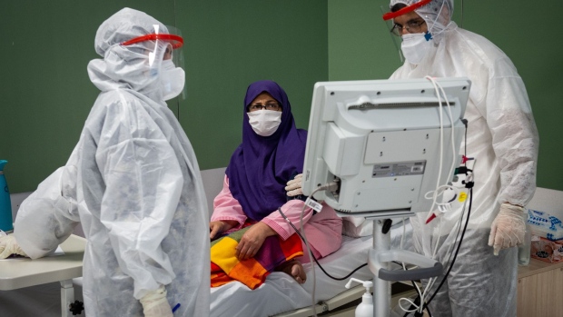 Medical staff wearing full personal protective equipment (PPE) tend to a Covid-19 patient beside a monitoring machine in a temporary coronavirus hospital at Iran Mall in Tehran, Iran, on Monday, April 13, 2020. Iran is seeking to gain access to $1.6 billion in assets that had been frozen in Luxembourg to help fight the coronavirus outbreak. Photographer: Ali Mohammadi/Bloomberg