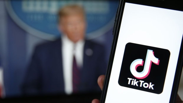 The TikTok logo is displayed in the app store in this arranged photograph in view of a video feed of U.S. President Donald Trump in London on Aug. 3. Photographer: Hollie Adams/Bloomberg