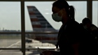 A traveler wearing a protective mask walks past an American Airlines Group Inc. plane tail fin at Ronald Reagan National Airport (DCA) in Arlington, Virginia, U.S., on Tuesday, June 9, 2020. U.S. airline shares last week headed for a record weekly gain as investors bet that travel demand was poised to rebound on signs that passengers were returning after the Covid-19 pandemic devastated demand.