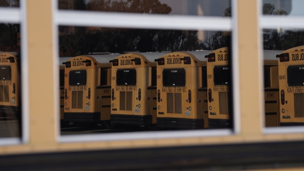 Navistar International Corp. school buses are seen reflected in the window of a bus stored at the San Diego Unified School District Transportation Department in San Diego, California, U.S., on Thursday, July 9, 2020. The U.S. economy is caught in the middle of President Trump's tug-of-war to reopen schools -- and could end up damned no matter what happens. Photographer: Bing Guan/Bloomberg