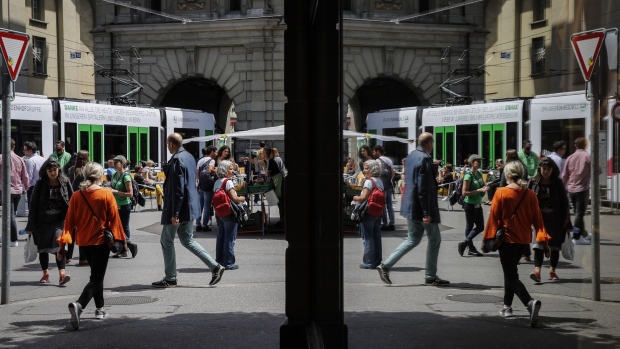 Pedestrians are reflected in a store window in Bern, Switzerland, on Thursday, June 18, 2020. The Swiss economy is expected to suffer its biggest contraction since the mid-1970s this year, with financial stability risks increasing globally due spiraling corporate and state debt.