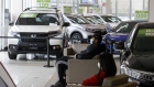 Customers wearing protective masks sit in a car dealership in Toronto, Ontario, Canada, on Tuesday, May 19, 2020. 