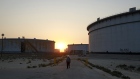 An employee walks past crude oil storage tanks at the Juaymah Tank Farm in Saudi Aramco's Ras Tanura oil refinery and oil terminal in Ras Tanura, Saudi Arabia, on Monday, Oct. 1, 2018. Saudi Arabia is seeking to transform its crude-dependent economy by developing new industries, and is pushing into petrochemicals as a way to earn more from its energy deposits.