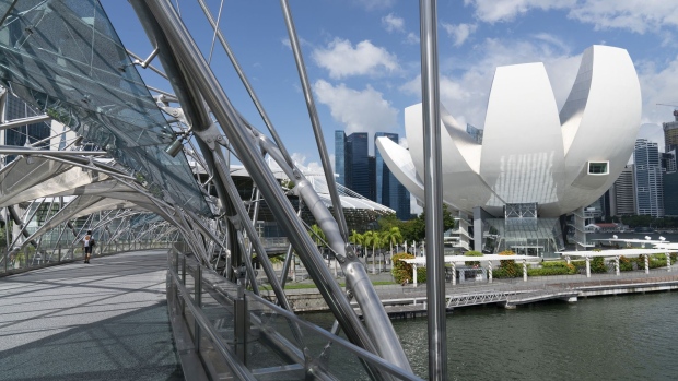 The Artscience Museum, right, is seen from the Helix Bridge by Marina Bay in Singapore on Monday, July 6, 2020. Prime Minister Lee Hsien Loong vowed to hand over Singapore “intact” and in “good working order” to the next generation of leaders, predicting the coronavirus crisis will “weigh heavily” on the nation’s economy for at least a year. Photographer: Wei Leng Tay/Bloomberg