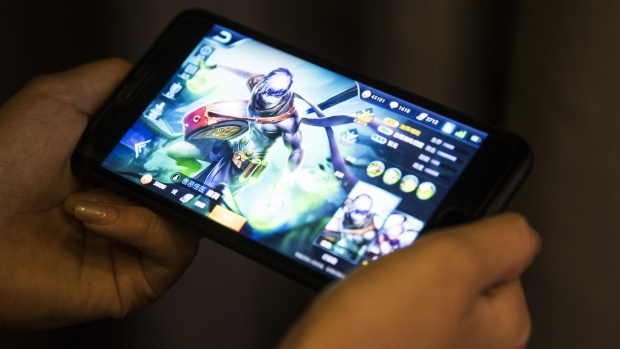 An avatar is displayed in an arranged photograph of the Honour of Kings mobile game, developed by Tencent Holdings Ltd., in Hong Kong, China, on Friday, Aug. 18, 2017. The mobile smash, where professional doppelgangers get paid to help newbies climb both social and gaming ladders, is expected to generate as much as $3 billion in revenue this year.