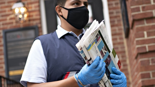 A United States Postal Service (USPS) letter carrier wearing a protective mask. Photographer: Andrew Harrer/Bloomberg