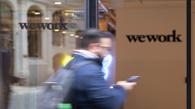 A pedestrian walks past the entrance to a We Work co-working office space. Photographer: Bryn Colton/Bloomberg