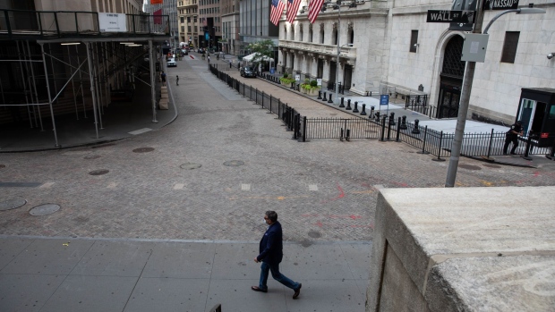 A pedestrian passes in front of the New York Stock Exchange (NYSE) in New York, U.S., on Monday, July 20, 2020. U.S. stocks fluctuated in light trading as investors are keeping an eye on Washington, where lawmakers will begin hammering out a rescue package to replace some of the expiring benefits earlier versions contained. Photographer: Michael Nagle/Bloomberg