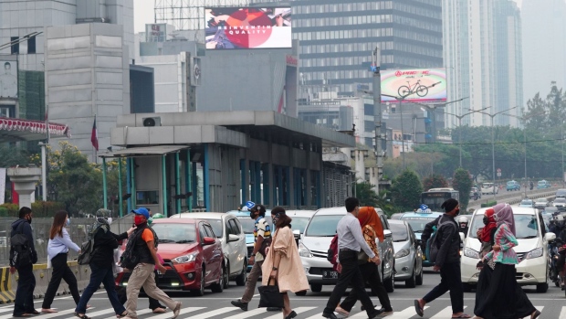 Morning commuters cross a street in Jakarta, Indonesia, on Tuesday, Aug. 4, 2020. Indonesia is scheduled to announce its second-quarter gross domestic product (GDP) figures on Aug. 5.