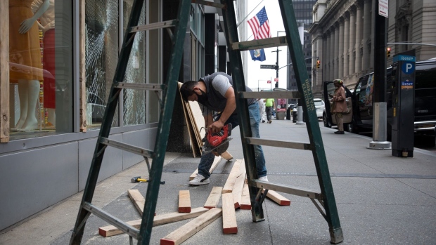 A worker boards up a Loft store in New York, U.S., on Wednesday, June 3, 2020. After more than two months in lockdown, this heart of global capitalism, the biggest city in the world’s biggest economy, faces a moment that couldn’t feel more fraught or have higher stakes. Photographer: Michael Nagle/Bloomberg