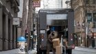 A United Parcel Service Inc. (UPS) delivery driver wearing a protective mask unloads packages onto a hand truck in San Francisco, California, U.S., on Monday, April 6, 2020. In the new coronavirus economy that divides labor into essential and nonessential, truckers and parcel delivery drivers have become some of the most indispensable -- and most exposed -- workers as shut-in Americans rely more on online shopping. Photographer: David Paul Morris/Bloomberg