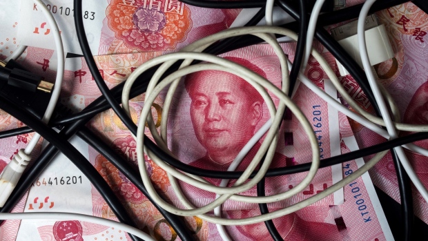 Cables sit on top of Chinese one-hundred yuan banknotes in an arranged photograph taken in Hong Kong, China, on Monday, April 15, 2019. China's holdings of Treasury securities rose for a third month as the Asian nation took on more U.S. government debt amid the trade war between the world’s two biggest economies. Photographer: Paul Yeung/Bloomberg