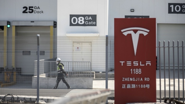 A worker walks past gates at the Tesla Inc. Gigafactory in Shanghai, China, on Monday, Feb. 17, 2020. Tesla has fully resumed deliveries of its China-built model 3 sedans, according to a company representative, after a pause due to the coronavirus outbreak.