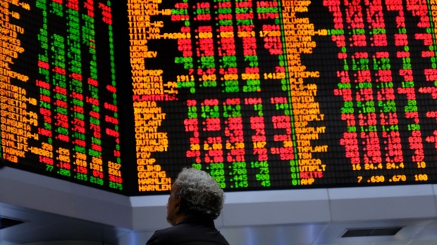 A person looks at stock prices displayed in the trading gallery of the RHB Investment Bank Bhd. headquarters in Kuala Lumpur, Malaysia, on Tuesday, Feb. 17, 2020. Malaysia is restricting people's movement nationwide to limit the spread of the coronavirus. The country is banning all visitors, and residents are barred from traveling overseas while places of worship, schools and business premises will be shut except for markets that supply daily needs, Prime Minister Muhyiddin Yassin said in a televised address late Monday. Photographer: Samsul Said/Bloomberg