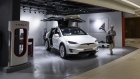 A man walks past a Tesla Model X electric vehicle on display at a showroom in Hong Kong.
